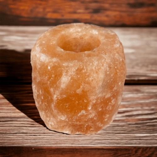 En rosa saltlampa som ligger på ett träbord.