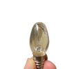 En hand håller en liten genomskinlig glödlampa.