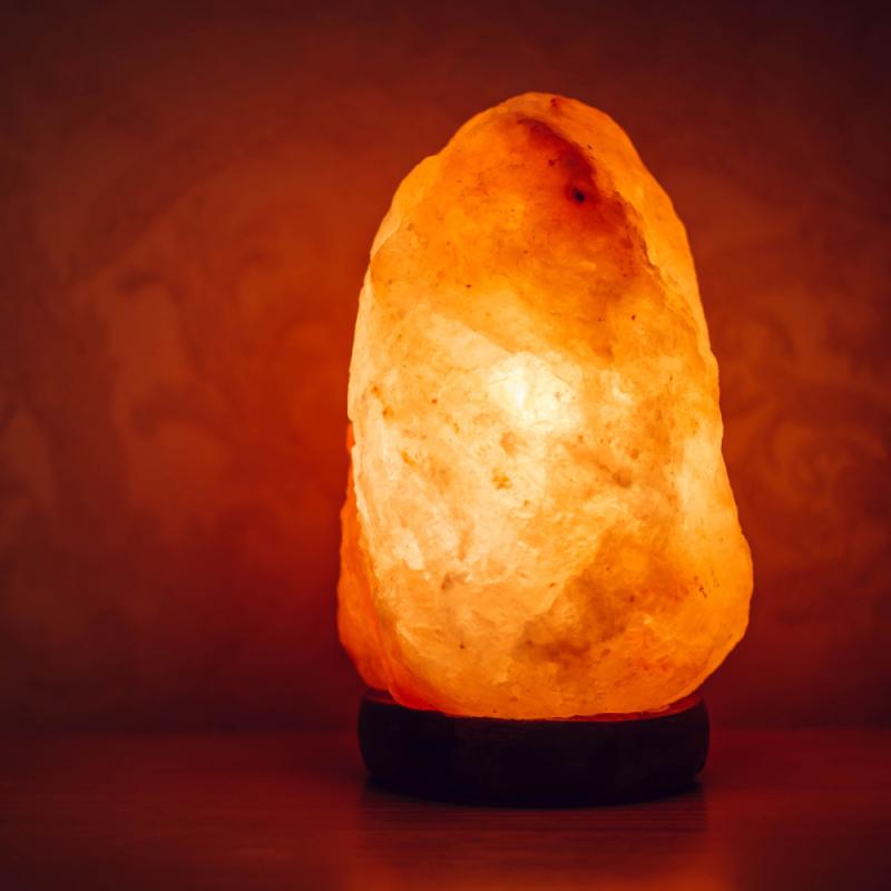 Ljusande saltlampa på träunderlag.